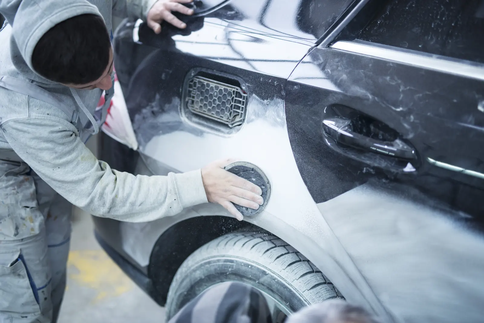A small panel being sanded smooth before a minor repair is painted